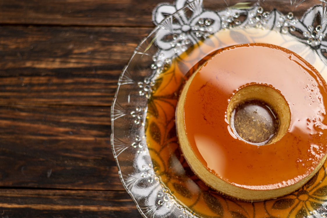 Milk Pudding or Pudim de leite. Brazilian dessert homemade caramel custard pudding. Traditional brazilian flan on wooden background